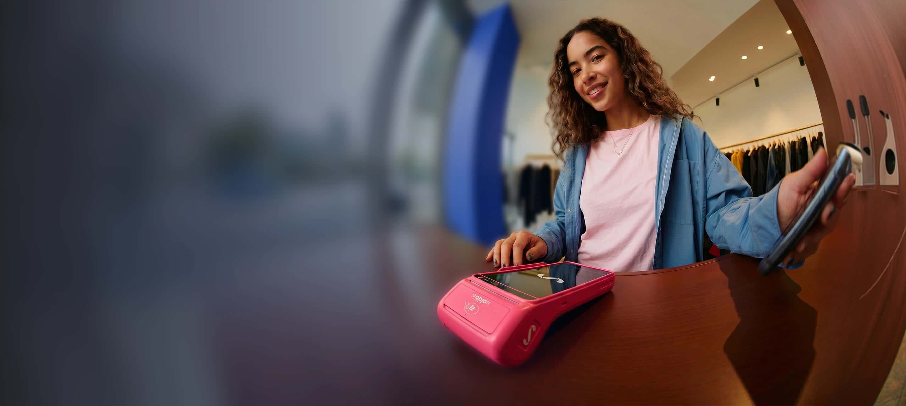 Imágen de una chica cobrando en su negocio